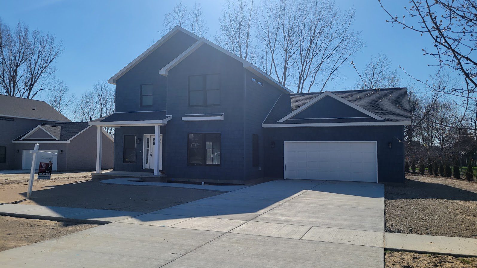 Garage and Porch(1) A large blue house with two garage doors.
